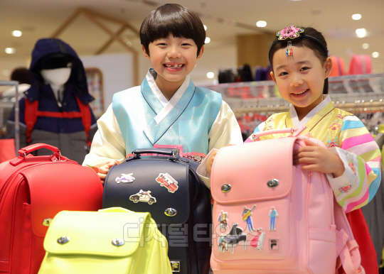 설을 앞두고 서울 소공동 롯데백화점 본점 휠라 키즈매장에서 아역스타 길정우, 김하유가 설 선물로 DIY 스티커를 이용한꾸민 비엘라 책가방을 선보이고 있다. 휠라코리아제공